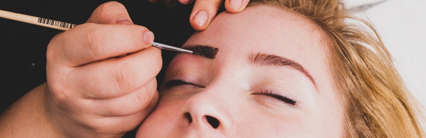 A woman getting eyelash & eyebrow services.